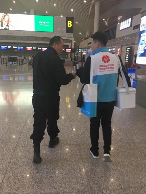 机场,在全体旅客的支持下,王海娇安排刘江志愿者首先下机,并与地面