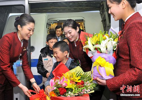 国航地面服务人员用鲜花迎接第一位下飞机的小旅客. 摄影:王泽民